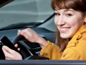 teen holding smartphone and driving